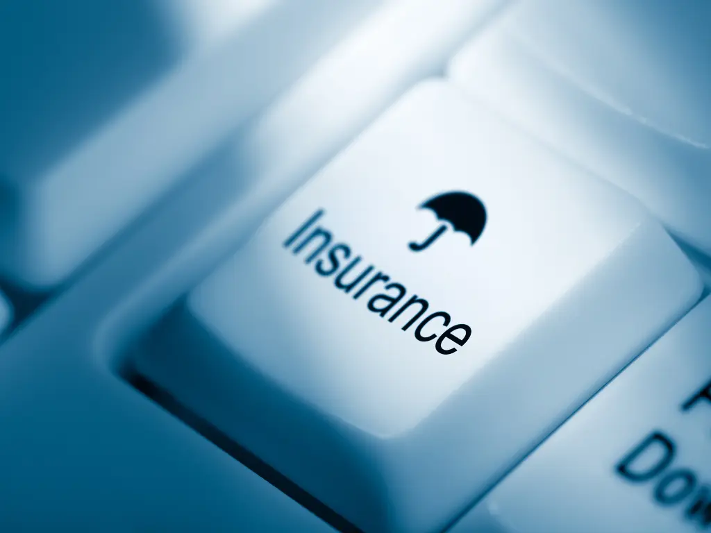 A close-up of a keyboard key labeled "Insurance" with an umbrella icon, symbolizing protection or insurance services.