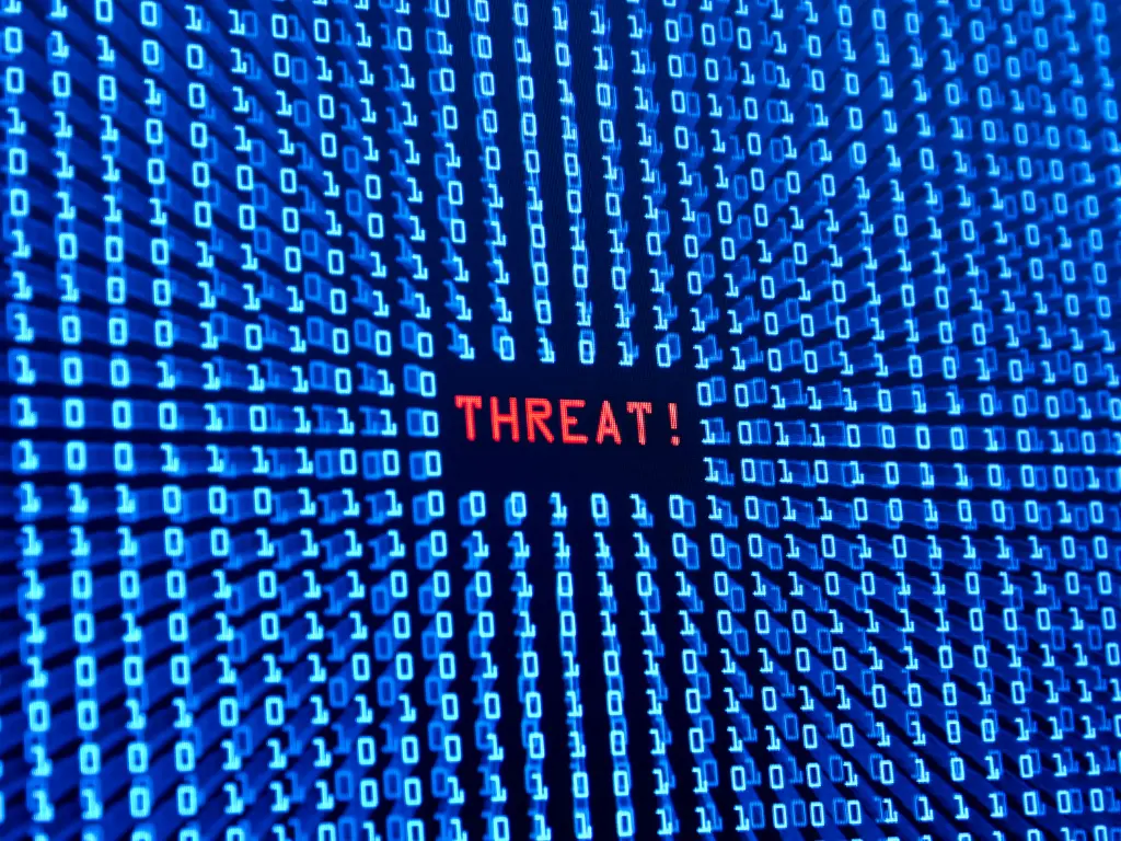 Rows of binary code surround the word "THREAT!" in red, highlighting a digital security warning or cyber threat message on a blue background.