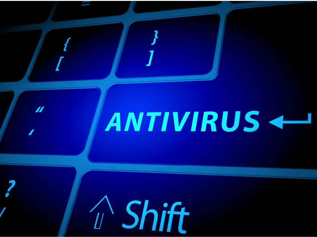 A close-up of a computer keyboard with the word "ANTIVIRUS" highlighted in blue next to an arrow symbol, emphasizing digital security.
