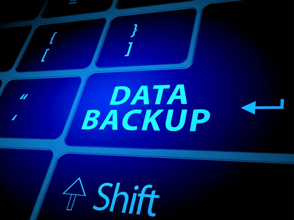 A close-up of a keyboard with a large blue key labeled "DATA BACKUP" next to the shift key, symbolizing data security and backup.