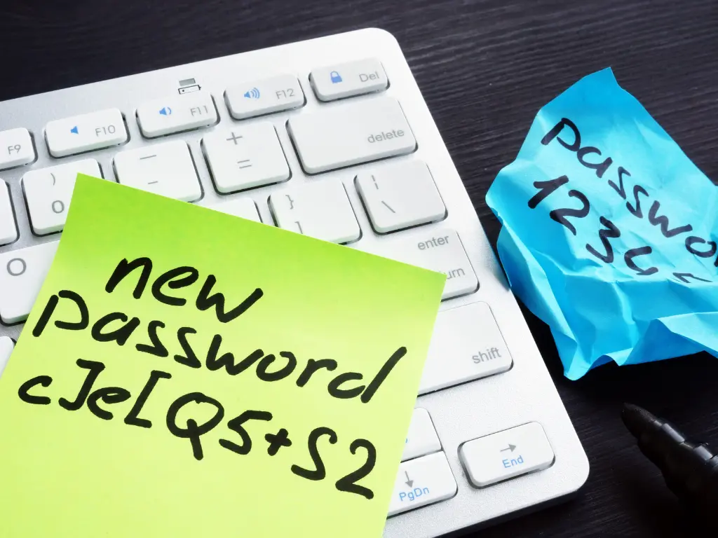 Sticky notes with passwords written on them resting on a computer keyboard, one note says "new password" and the other says "password 1234".