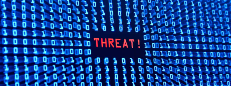 Rows of blue binary code surround the red word "THREAT!" on a dark digital screen, symbolizing a cybersecurity or computer virus warning.