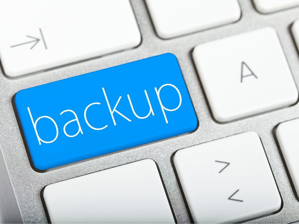 A close-up of a computer keyboard with a large blue key labeled "backup" in white letters, symbolizing data backup or security.