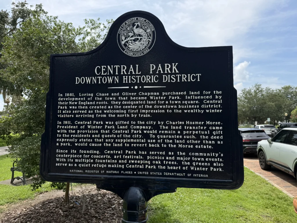 Historic marker sign for Central Park Downtown Historic District in Winter Park, Florida, describing its origins, founders, and role as a community centerpiece.